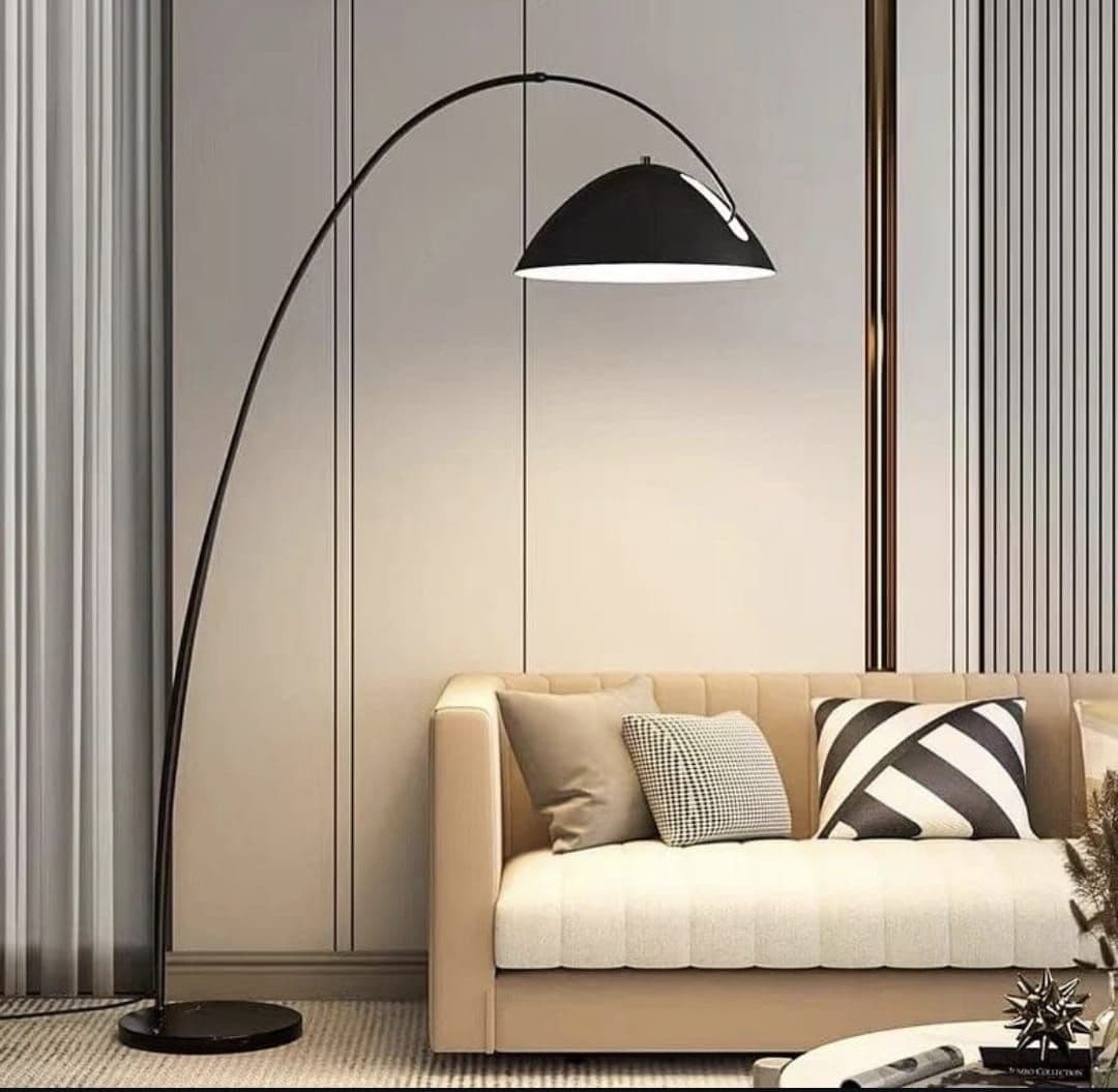 Black arc floor lamp curving over a cream sofa in a living room