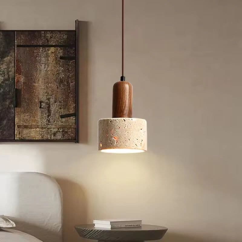 Travertine pendant light hanging over a counter beside framed artwork