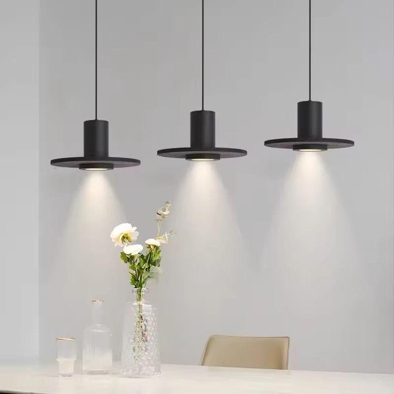 Three black marble pendant lights hanging in a row above a kitchen counter