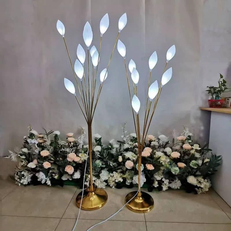 Two LED leaf floor lights lit warm white, gold branches with frosted petals