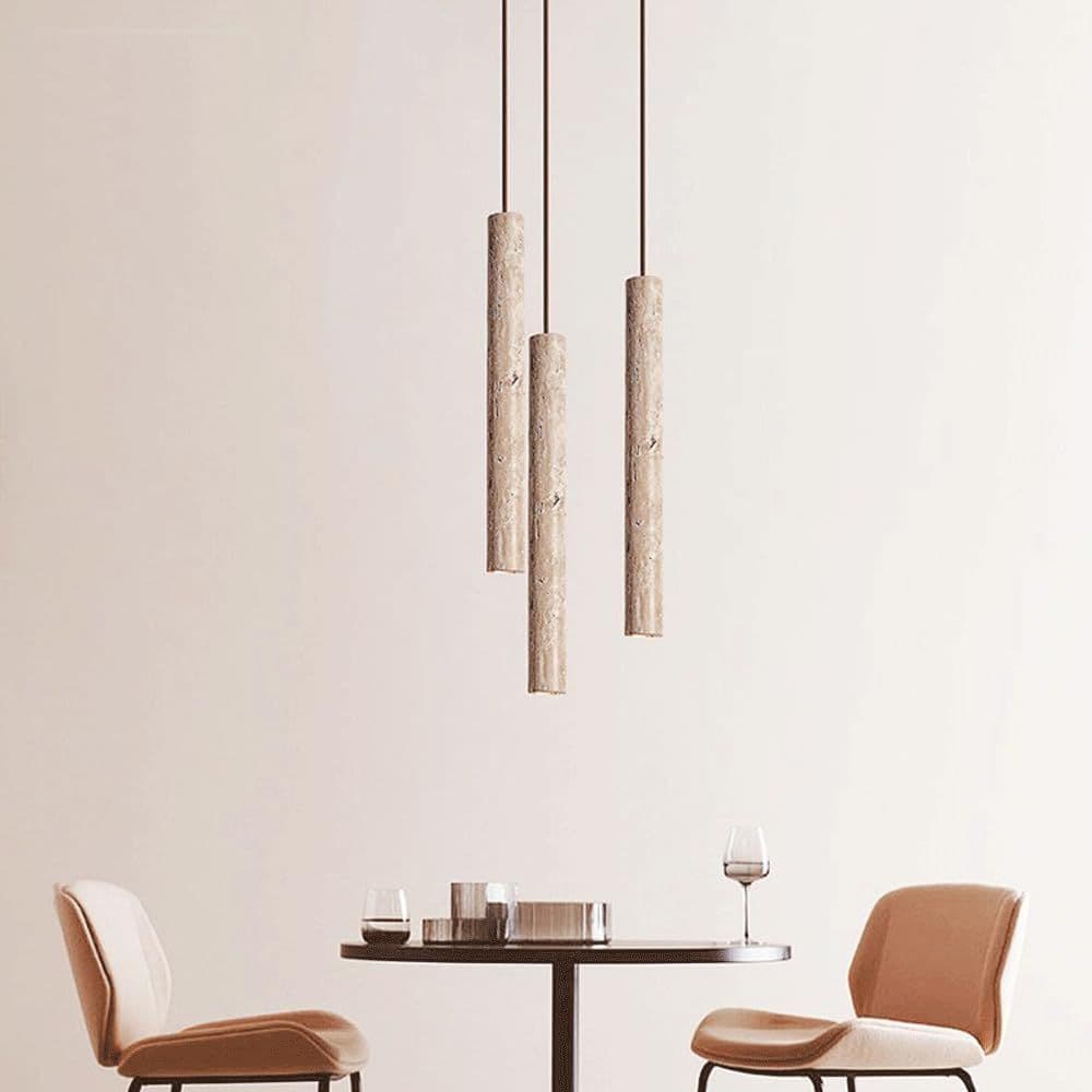 Two travertine tube pendant lights hanging over a dining table