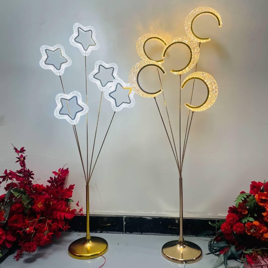 LED star tree floor lights in white and gold, styled with red floral accents