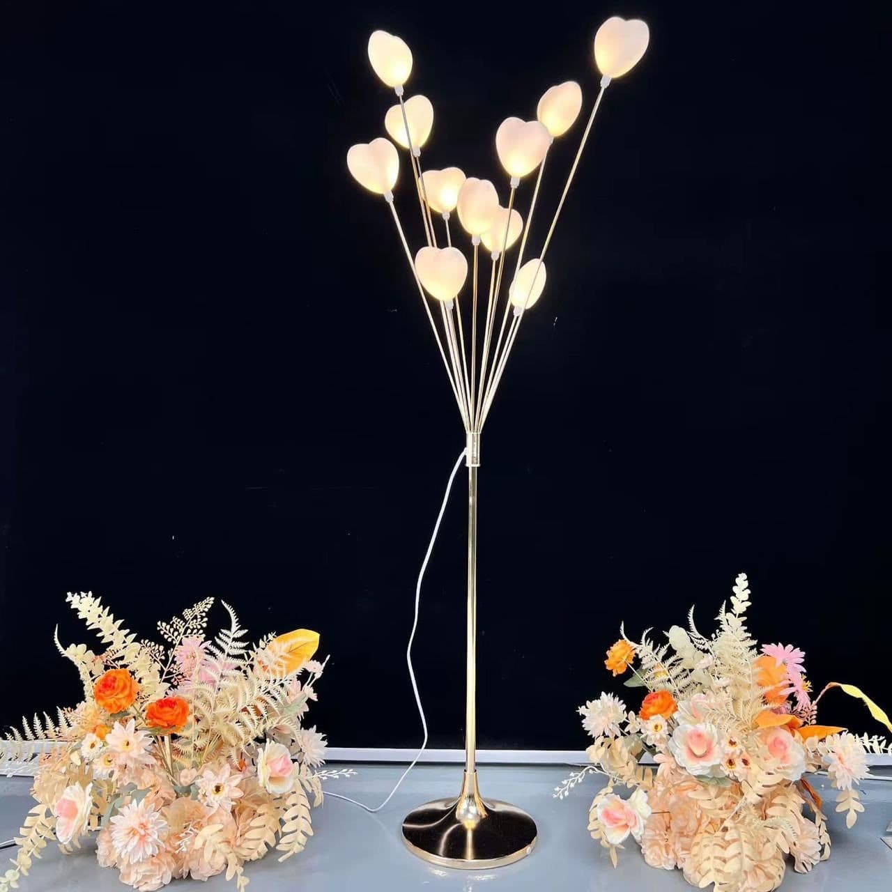 Gold branch uplight with warm white LEDs styled as a table centrepiece with florals