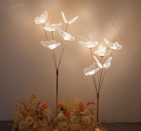 Acrylic butterfly uplighting stems lit warm at dusk