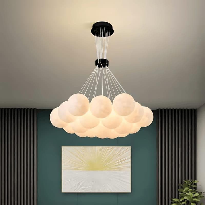 Cloud cluster glass chandelier lit warm in a room setting