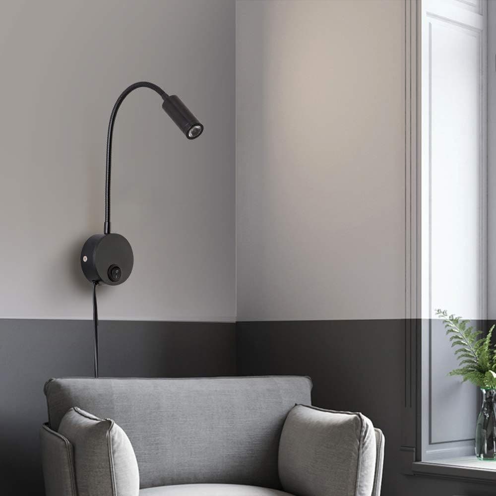 Black reading light mounted on a wall beside a living room chair