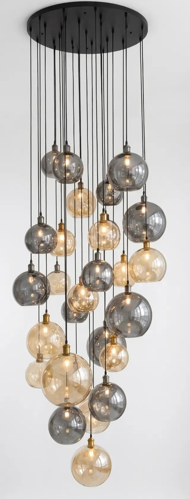 Glass globe cluster pendant light with smoky and gold glass shades on plain background